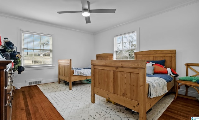 bedroom featuring light wood-style flooring, multiple windows, and ornamental molding