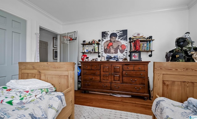 bedroom with wood finished floors and crown molding