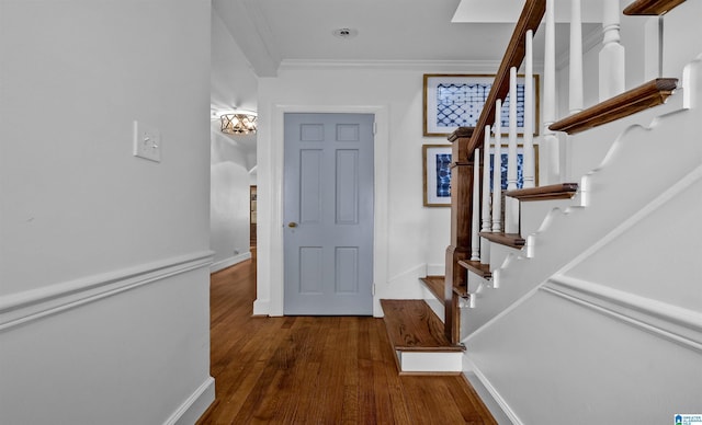 foyer entrance with stairway, baseboards, wood finished floors, and crown molding