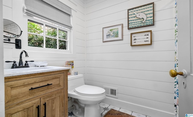 bathroom with vanity, toilet, and visible vents