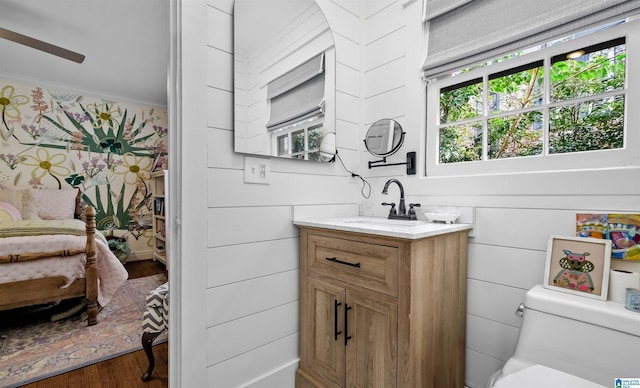 bathroom with vanity, crown molding, toilet, and wood finished floors