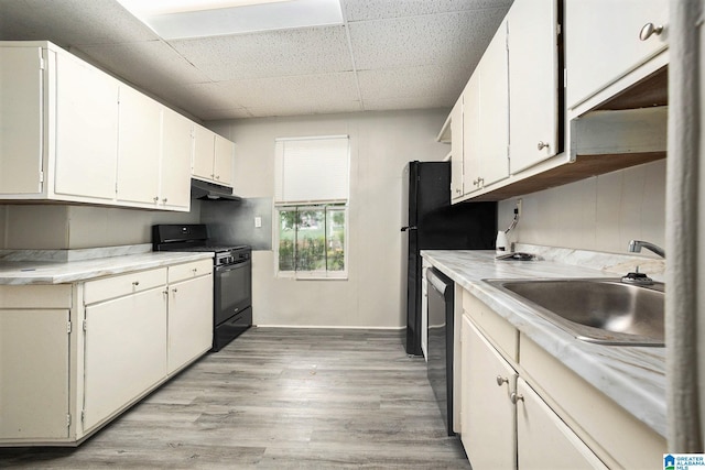 kitchen with black range with gas cooktop, dishwasher, light countertops, under cabinet range hood, and a sink