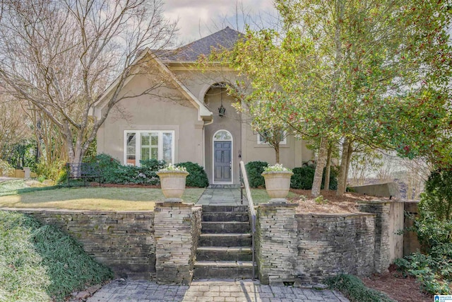 view of front facade with a front yard and stucco siding