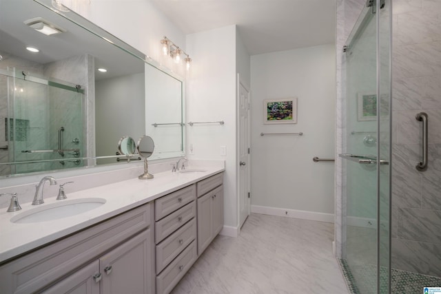 bathroom featuring marble finish floor, a sink, a shower stall, and double vanity