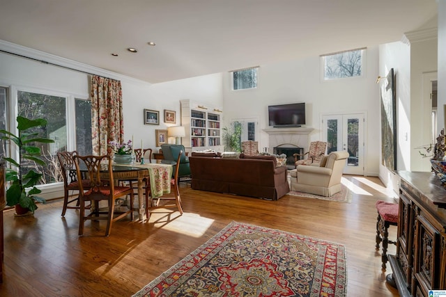 dining area featuring crown molding, french doors, a fireplace, and wood finished floors