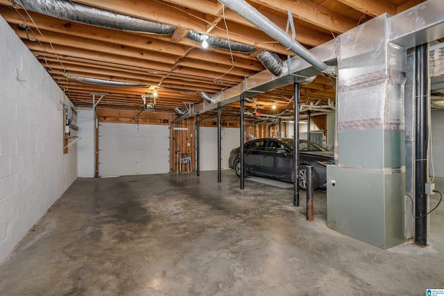 garage with a garage door opener and concrete block wall