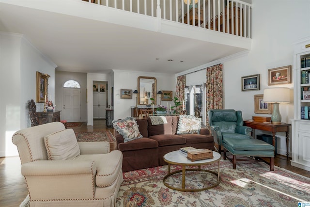 living room featuring crown molding, a high ceiling, and wood finished floors