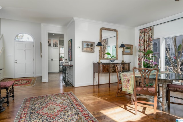 foyer entrance with baseboards, ornamental molding, and wood finished floors