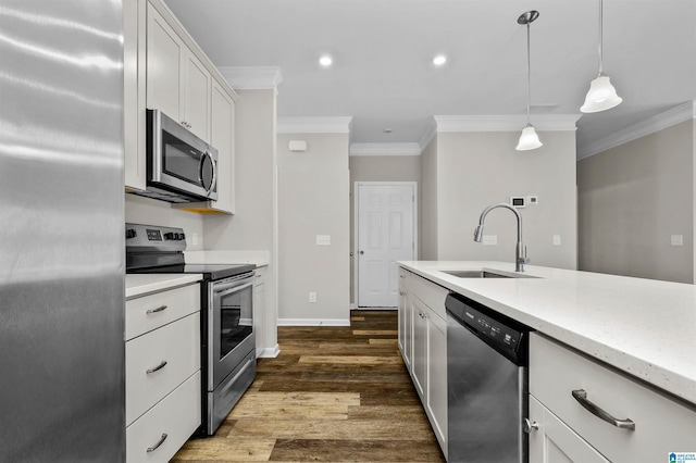 kitchen featuring a sink, white cabinetry, ornamental molding, appliances with stainless steel finishes, and dark wood-style floors