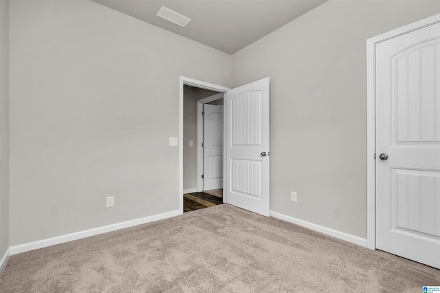 unfurnished bedroom featuring carpet, visible vents, and baseboards