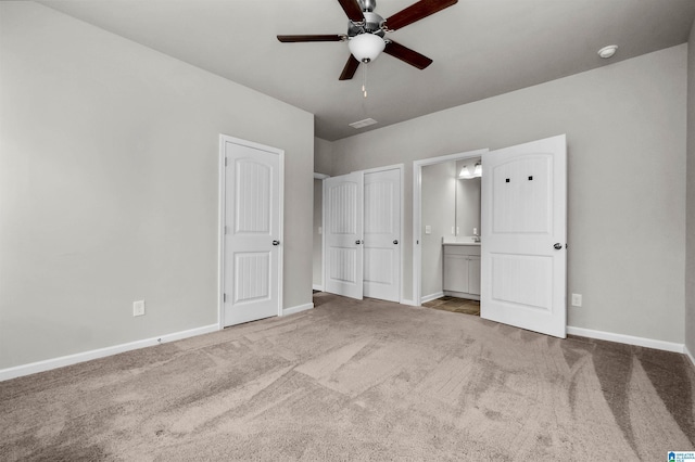 unfurnished bedroom featuring a ceiling fan, carpet flooring, baseboards, and ensuite bathroom