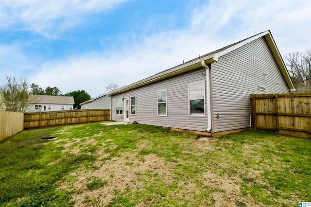 back of house featuring a fenced backyard and a yard