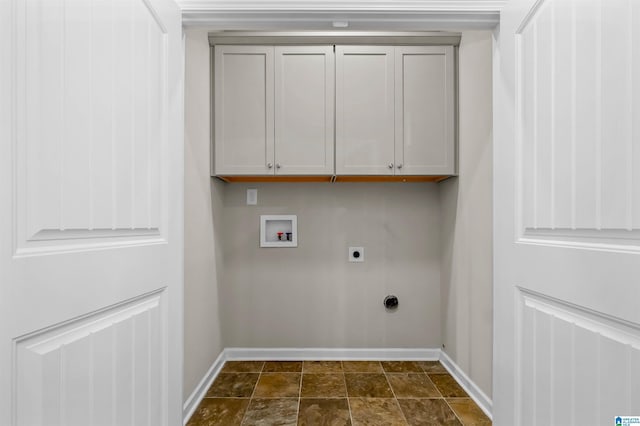 clothes washing area featuring hookup for a washing machine, cabinet space, stone finish floor, electric dryer hookup, and baseboards