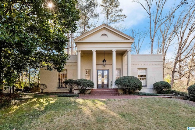 neoclassical home featuring french doors, a front yard, and stucco siding