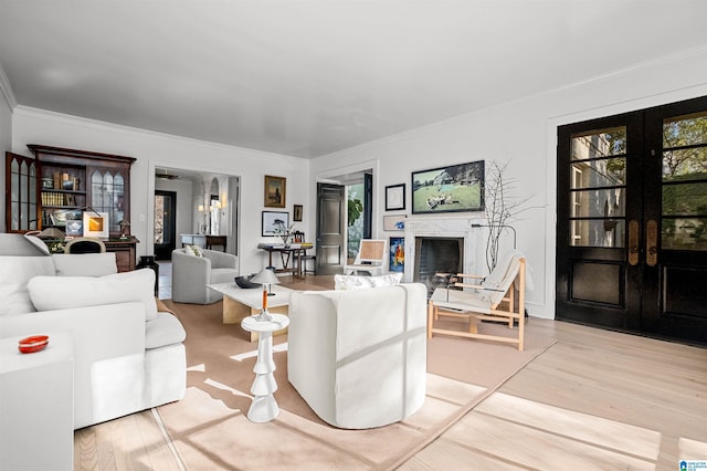 living room with french doors, a fireplace, crown molding, and wood finished floors