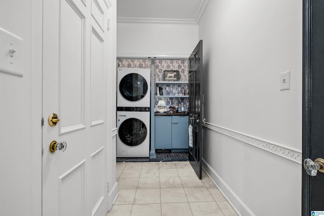 clothes washing area featuring stacked washer / dryer and crown molding