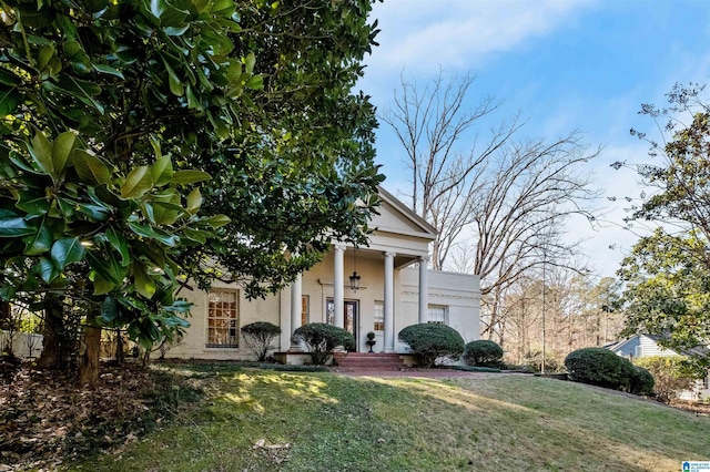 neoclassical home featuring a front yard and stucco siding