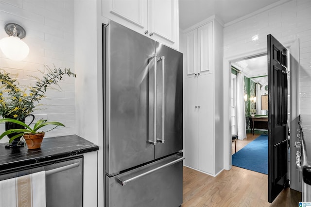 kitchen with light wood finished floors, high end refrigerator, and white cabinets