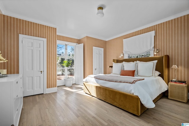 bedroom featuring wood finished floors, multiple closets, baseboards, wallpapered walls, and crown molding