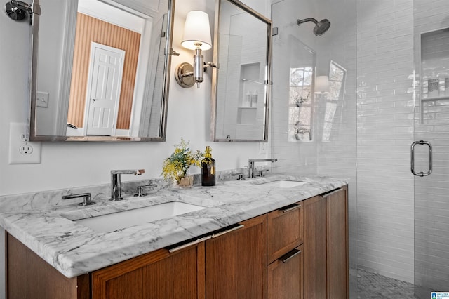 full bathroom with a sink, a shower stall, and double vanity