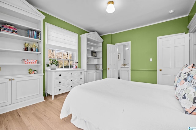 bedroom with light wood-type flooring and crown molding