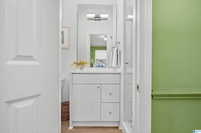 full bath featuring a shower, vanity, and wood finished floors