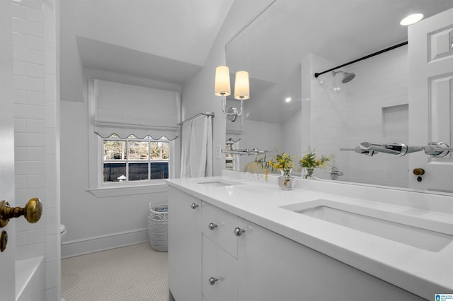 bathroom with lofted ceiling, a sink, a shower, tile patterned floors, and double vanity