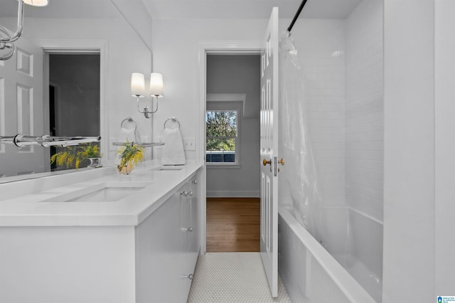 bathroom featuring shower / tub combo, a sink, baseboards, and double vanity