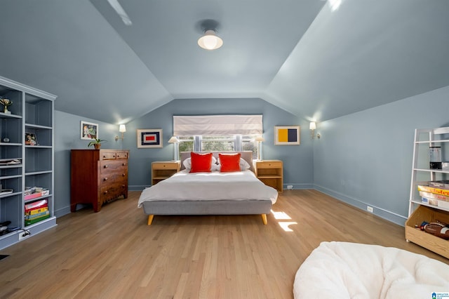 bedroom with lofted ceiling, baseboards, and wood finished floors