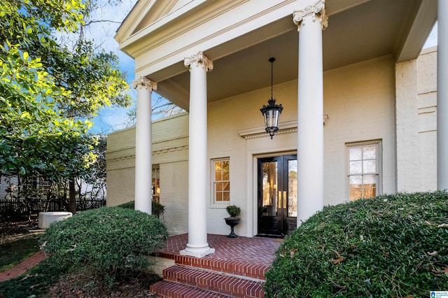 view of exterior entry with french doors and stucco siding