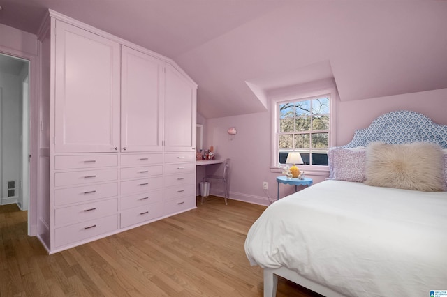 bedroom with light wood-type flooring, lofted ceiling, and baseboards