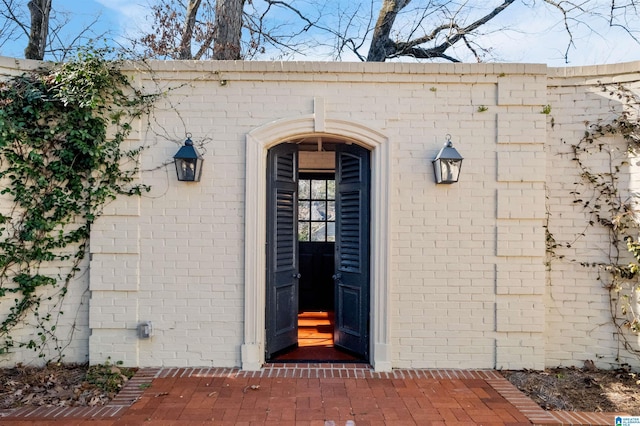 entrance to property featuring brick siding