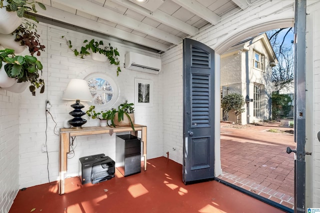 foyer featuring brick wall, beamed ceiling, and a wall unit AC