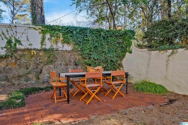 view of patio with outdoor dining space and fence