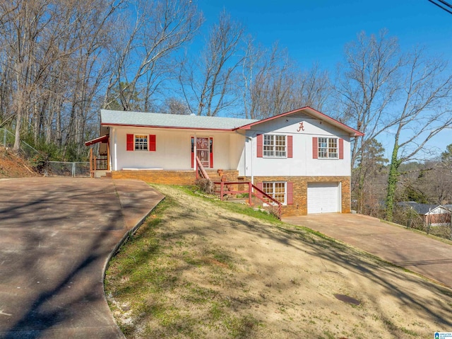 view of front facade with driveway, stucco siding, a garage, and brick siding