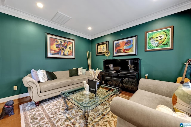 living area with baseboards, visible vents, crown molding, and wood finished floors