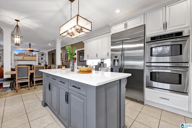 kitchen with gray cabinets, appliances with stainless steel finishes, light tile patterned flooring, ceiling fan, and ornate columns