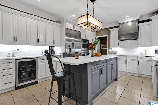 kitchen with wine cooler, a kitchen island, gray cabinets, stainless steel appliances, and premium range hood