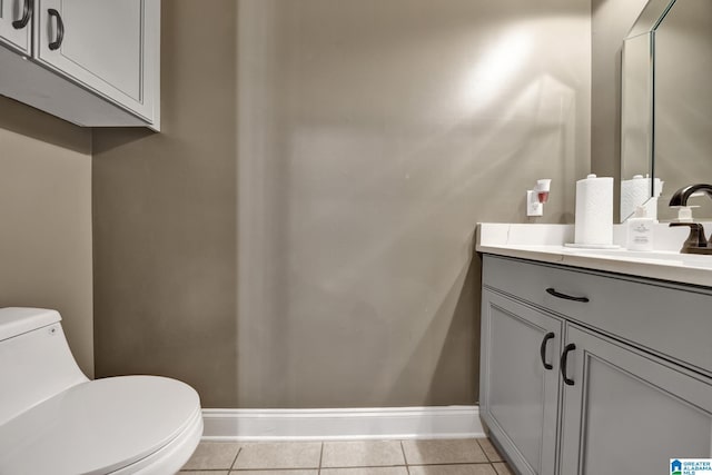 bathroom featuring tile patterned flooring, baseboards, vanity, and toilet