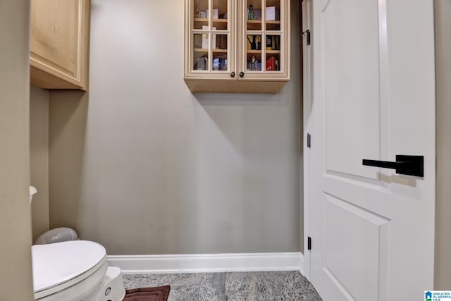 half bathroom with toilet and baseboards