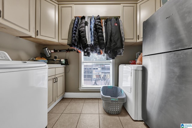 laundry room featuring light tile patterned floors, cabinet space, and washer / dryer