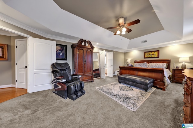 bedroom featuring visible vents, ornamental molding, a tray ceiling, and carpet flooring