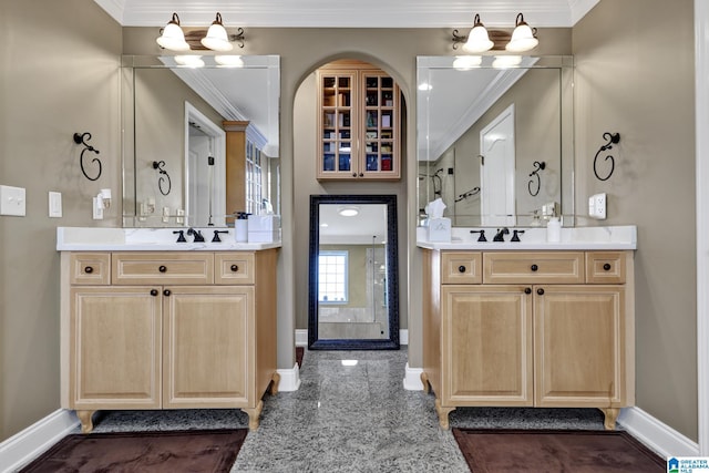 full bathroom featuring ornamental molding, granite finish floor, two vanities, and baseboards