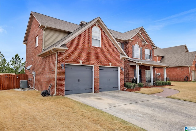 traditional-style home with cooling unit, concrete driveway, brick siding, and a front lawn