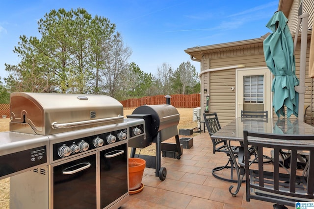 view of patio with fence, outdoor dining area, and area for grilling