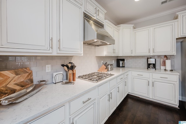 kitchen with dark wood-style flooring, crown molding, stainless steel gas cooktop, white cabinets, and under cabinet range hood