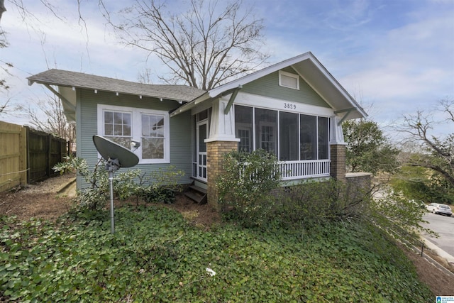 view of front of house featuring a sunroom and fence