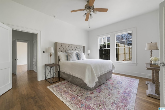 bedroom with ceiling fan, baseboards, and hardwood / wood-style flooring