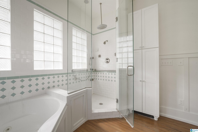 full bath featuring a garden tub, a shower stall, plenty of natural light, and wood finished floors