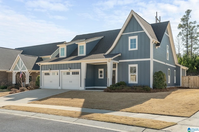 view of front of home with a shingled roof, concrete driveway, board and batten siding, fence, and a garage